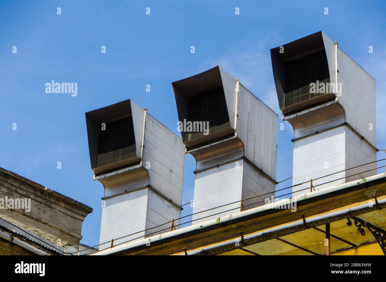 3 condotti d'aria in fila sul tetto di un edificio Foto Stock