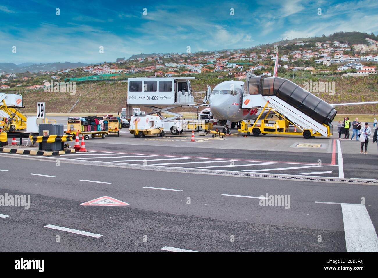 I turisti lasciano un aereo Jet2 a Madeira mentre gli equipaggi arrivano per scaricare i bagagli e per alimentare e servire l'aereo pronto per il suo prossimo volo Foto Stock