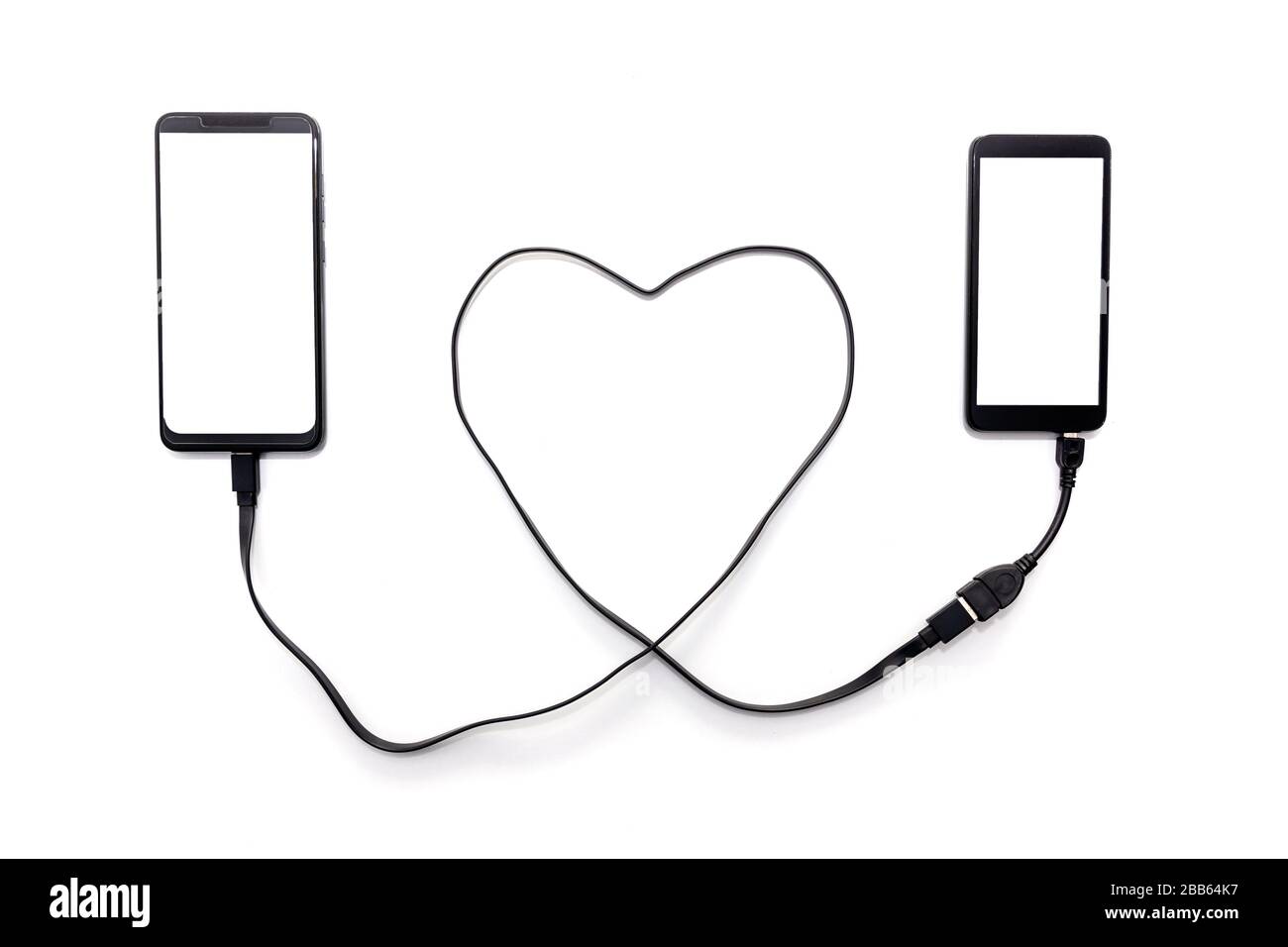Collegamento manuale di due smartphone con un cavo USB a forma di cuore. Concetto di relazione a lunga distanza. Foto Stock