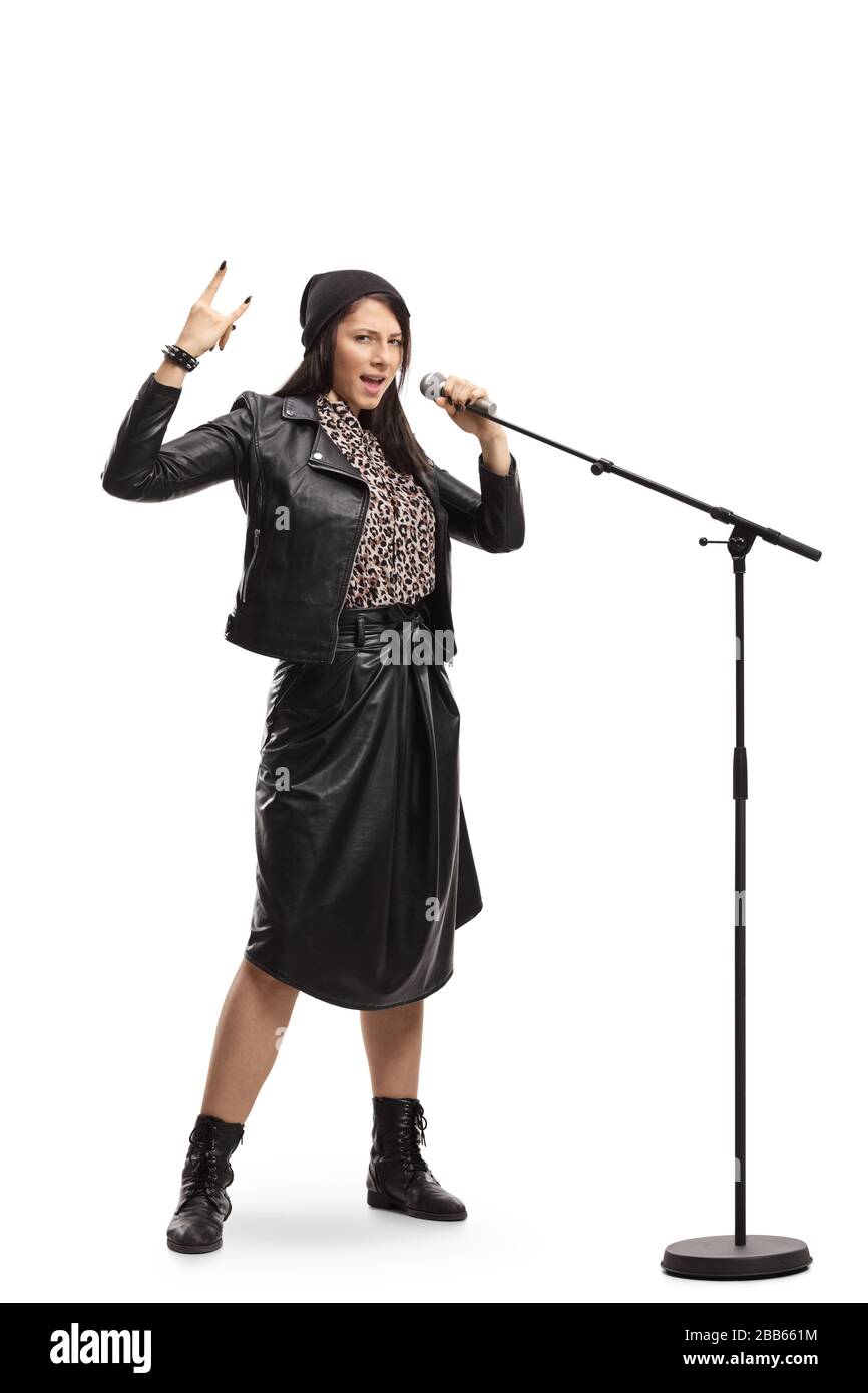 Ritratto a tutta lunghezza di un canto femminile e gesturante rock e roll segno isolato su sfondo bianco Foto Stock