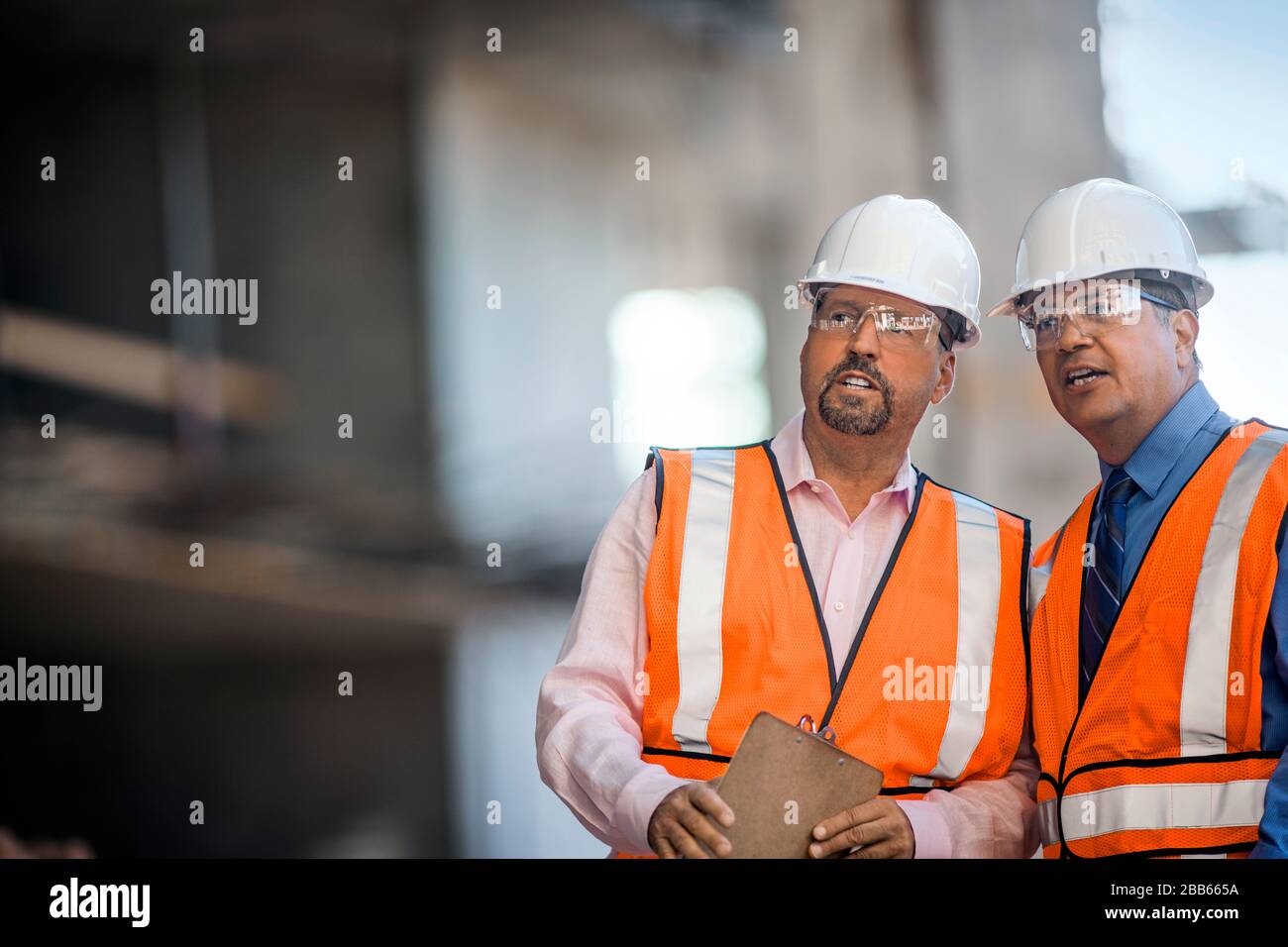 Lavoratori sul cantiere di discutere i progressi compiuti. Foto Stock