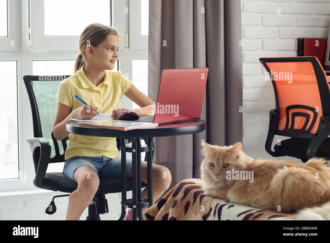 La ragazza sta studiando a casa sull'apprendimento a distanza, distracted ed ha guardato fuori la finestra Foto Stock