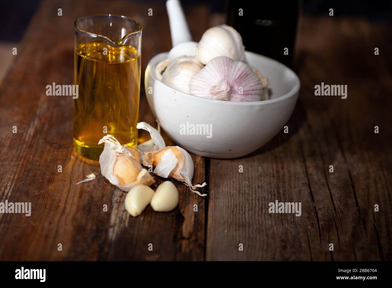 Olio d'aglio e aglio su un tavolo di legno. Foto Stock