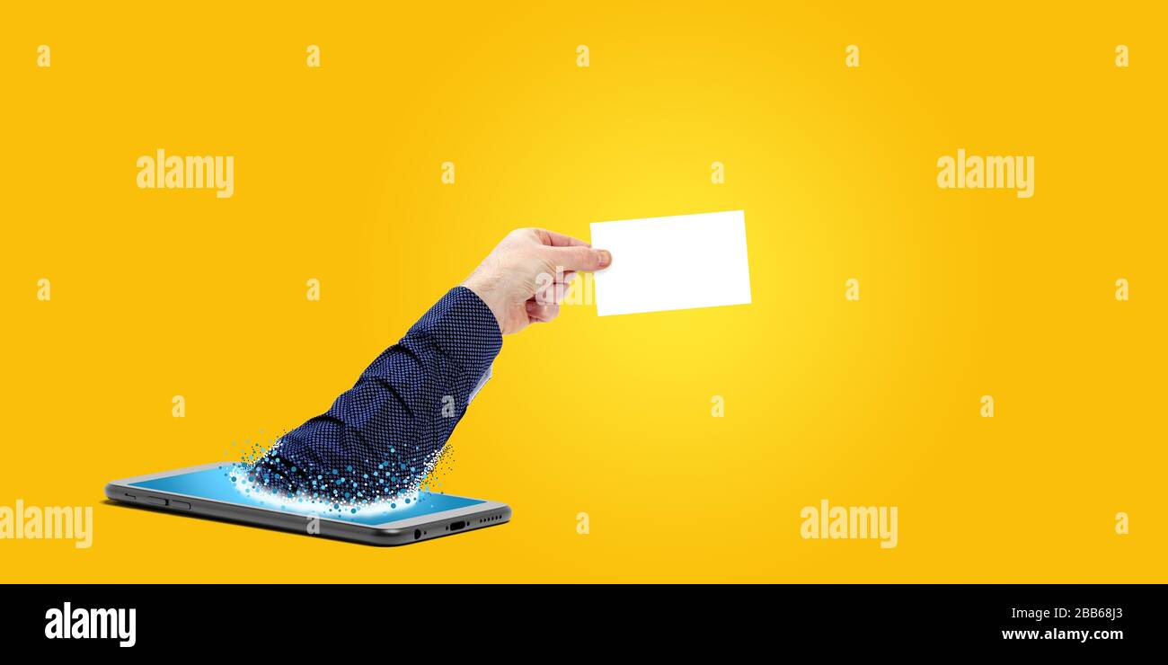 smartphone con sfondo giallo a mano e carta Foto Stock