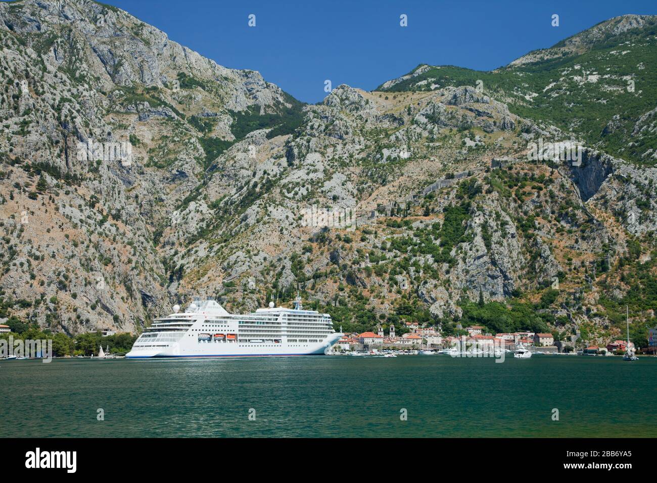 Kotor Bay con nave da crociera Silverseas Silver Muse in primo piano e Cattaro Town in background, Montenegro Foto Stock