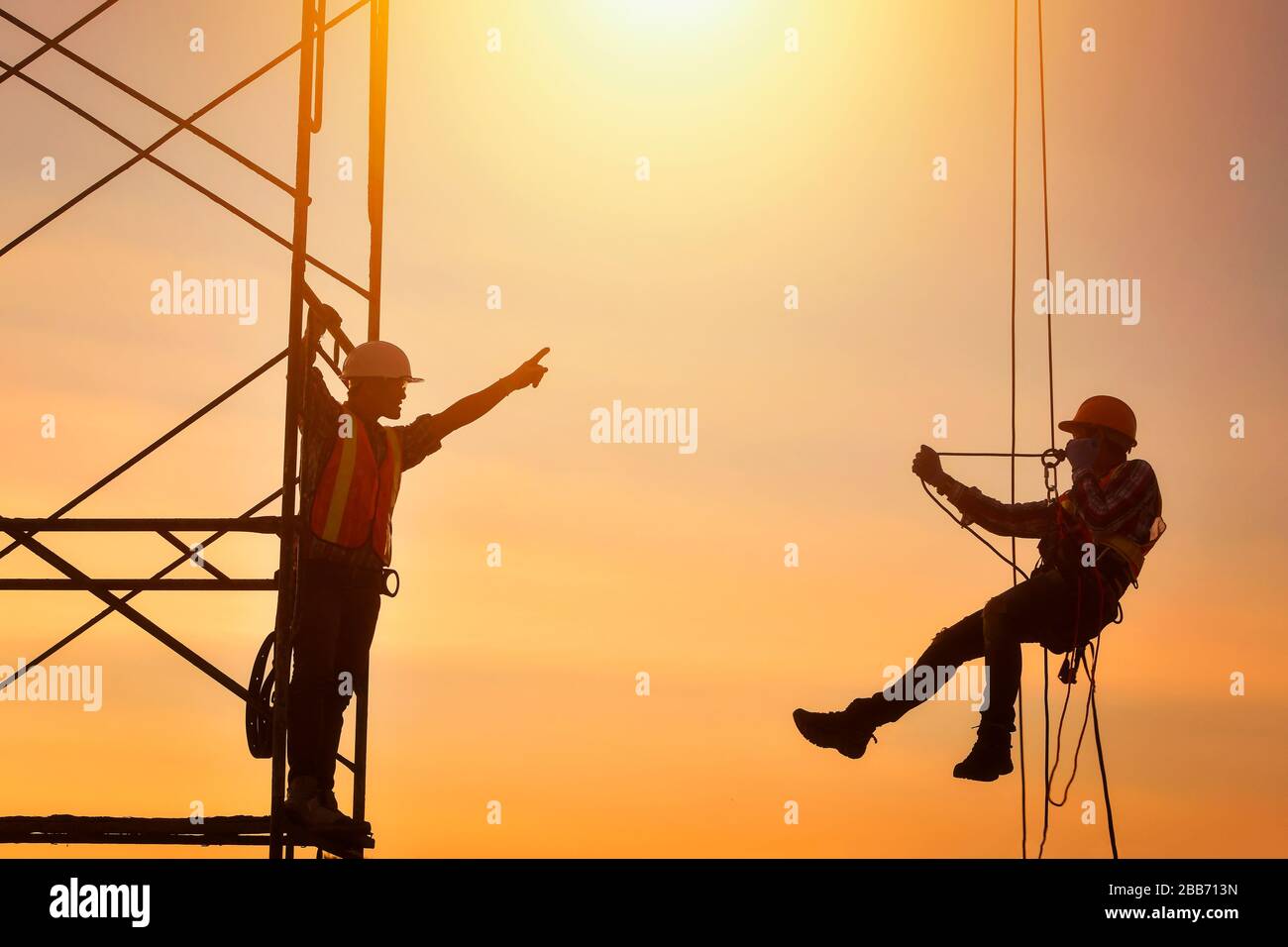 Silhouette di due operai edili in cantiere, Thailandia Foto Stock