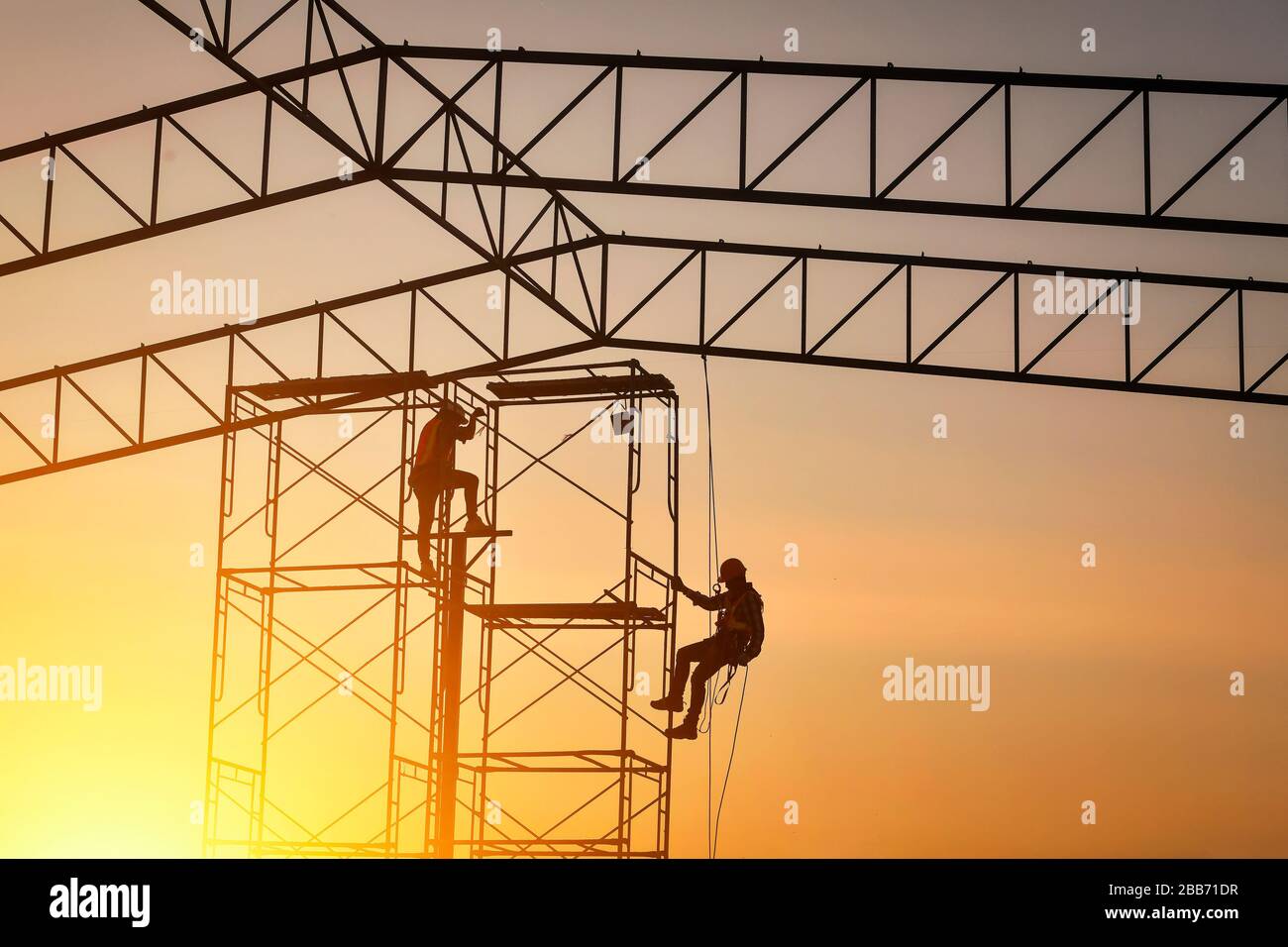 Silhouette di due operai edili in cantiere, Thailandia Foto Stock