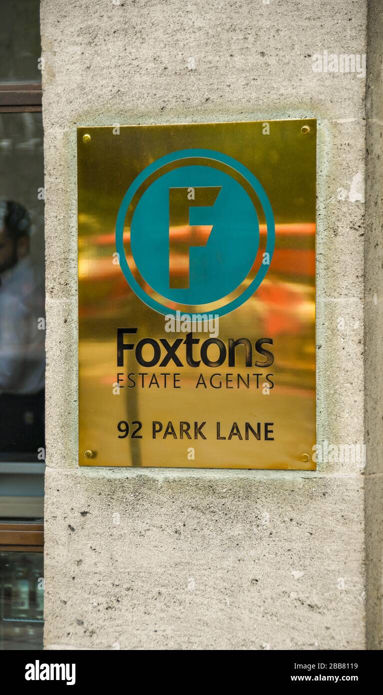 LONDRA, INGHILTERRA - GIUGNO 2018: Cartello in ottone sul muro fuori dagli uffici degli agenti immobiliari Foxtons sul Park Lane nel centro di Londra Foto Stock