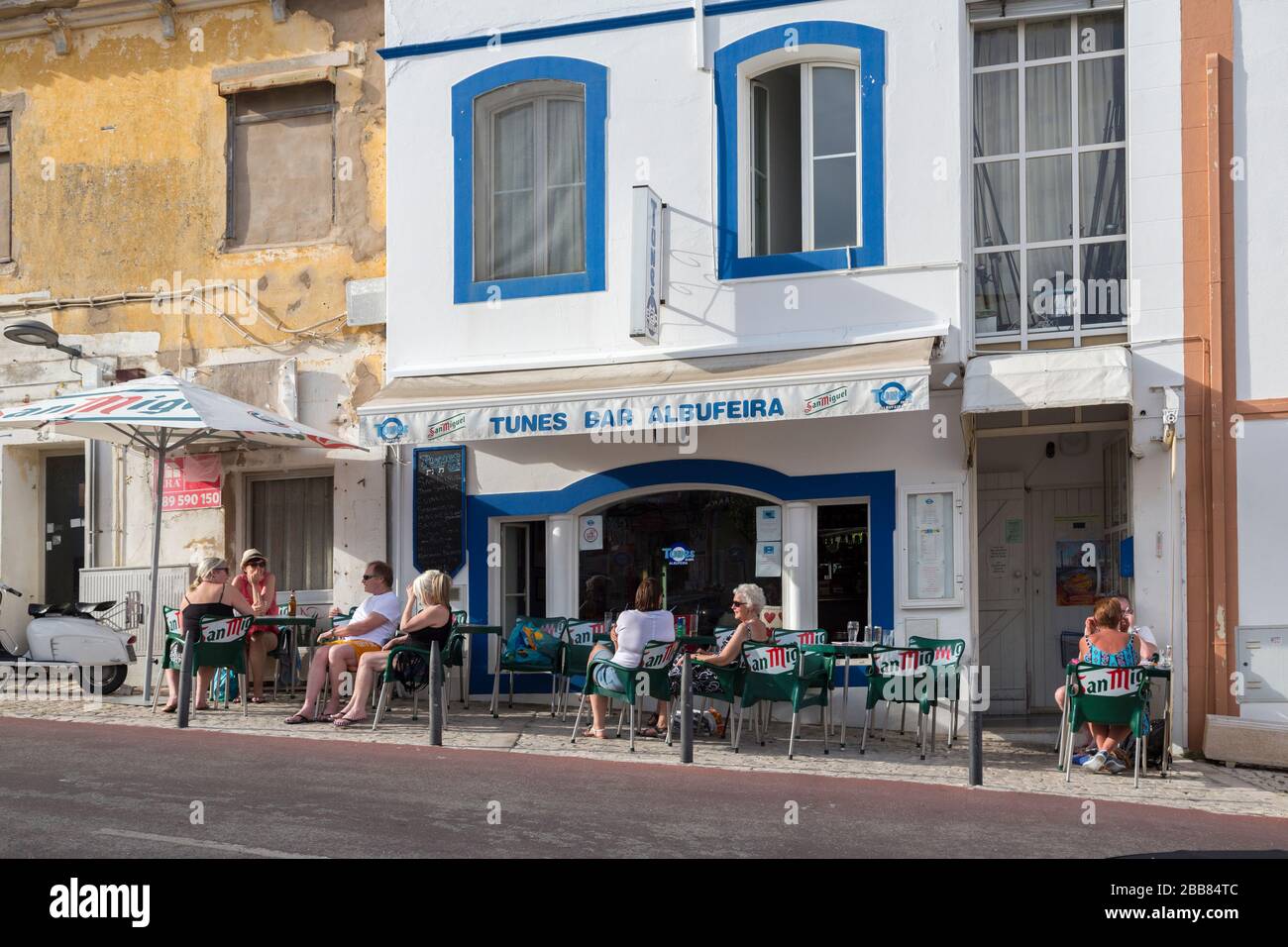 Persone in un bar che beve all'aperto ai margini della strada, Albufeira, Algarve, Portogallo Foto Stock