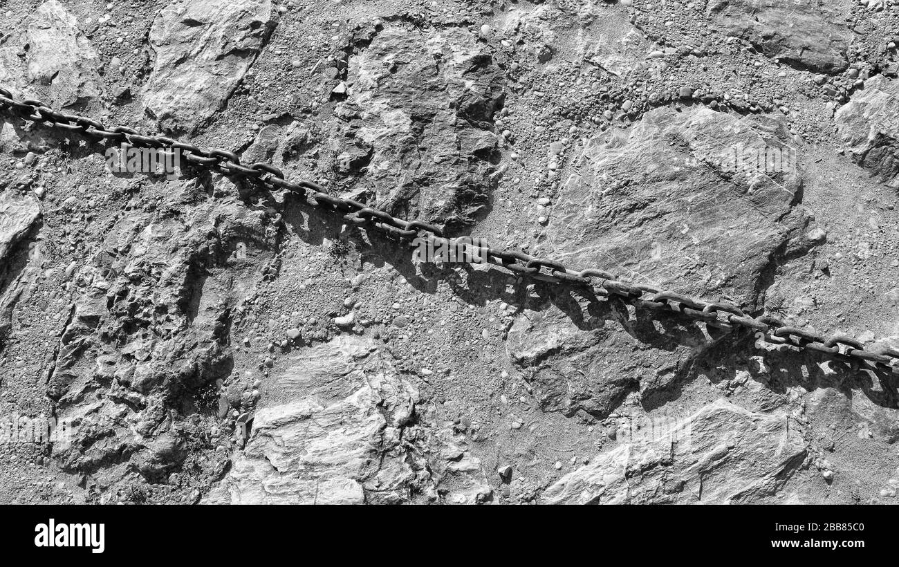 Catena in ferro su pavimento in pietra Foto Stock