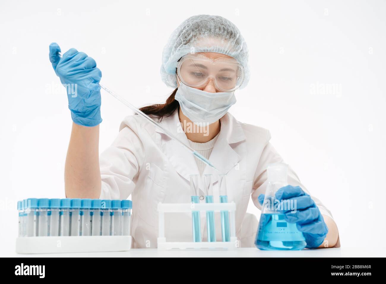 donna in maschera e occhiali di protezione che prende il campione per fare il test di coronavirus in laboratorio Foto Stock