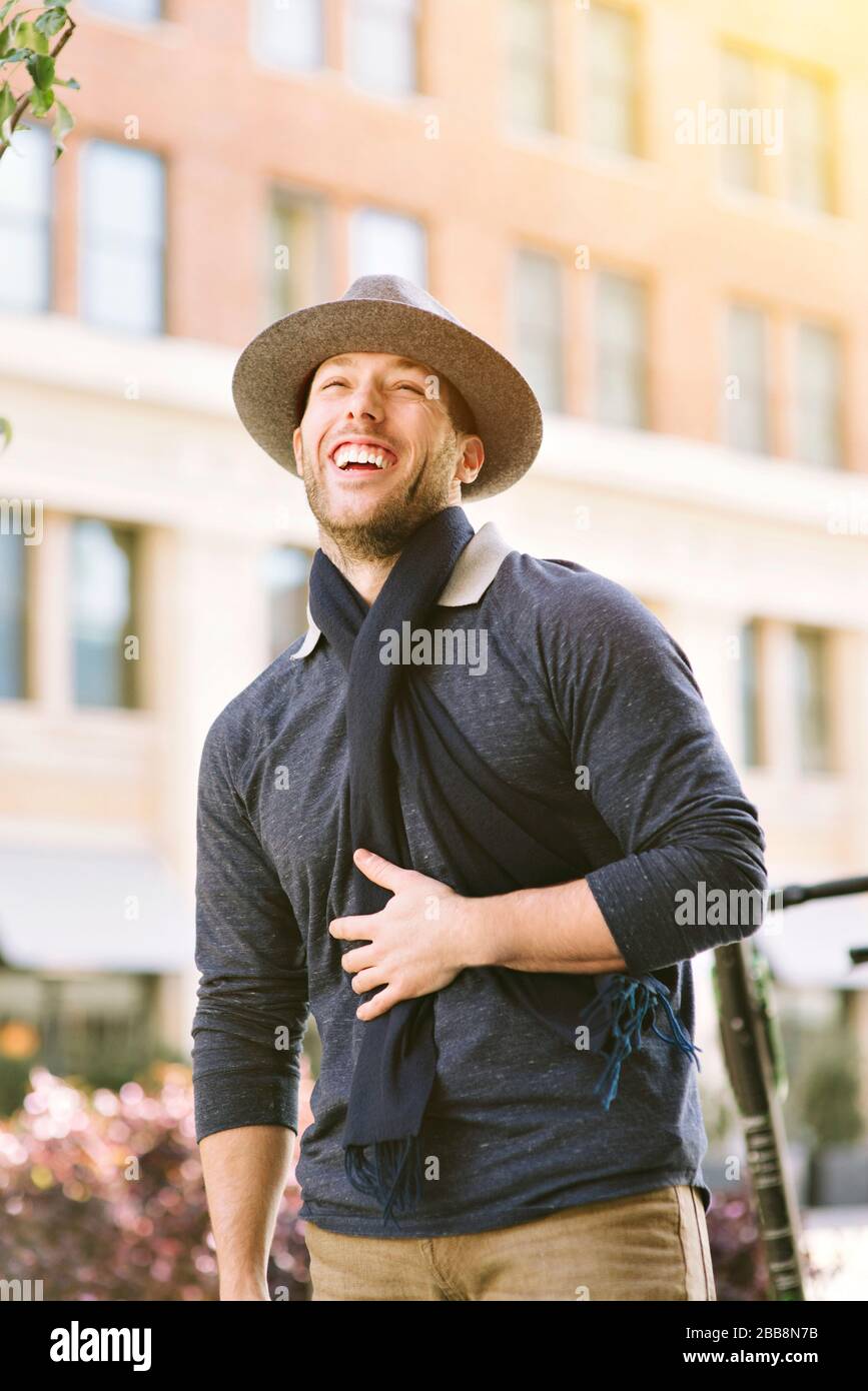 Giovane uomo millenario mostra un enorme sorriso mentre all'aperto in città - Urbano - alla moda - felice emozione Foto Stock