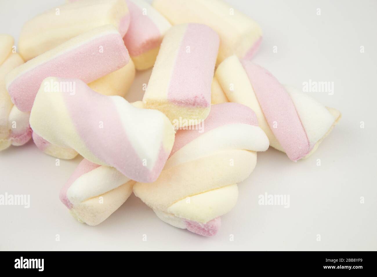 Marshmallow multicolore. Marshmallows di meringa in una tazza verde su uno sfondo chiaro. Meringhe colorate su sfondo bianco. Un sacco di dolce marshmal Foto Stock