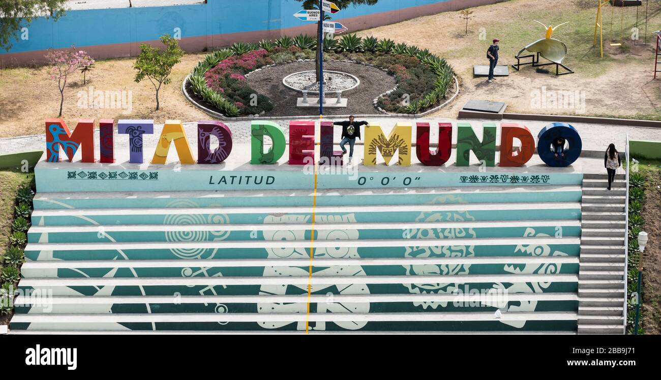 QUITO, ECUADOR - 29 LUGLIO 2018: Un uomo pone per una foto con il segno delle lettere di Mitad del Mundo. Foto Stock