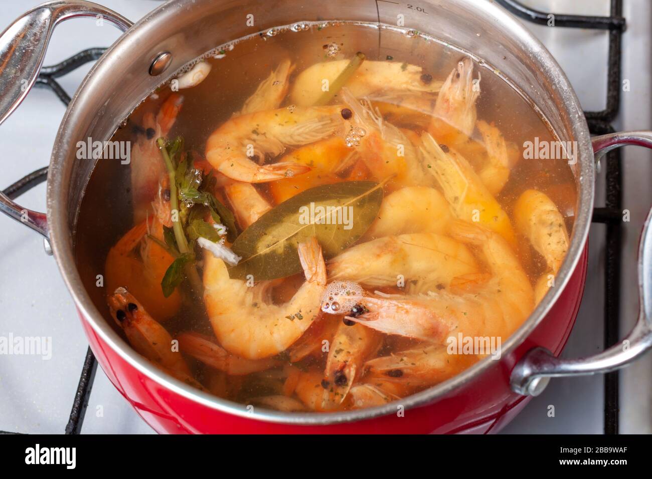 Pan con gamberi re cucinare con spezie sulla stufa, primo piano Foto Stock