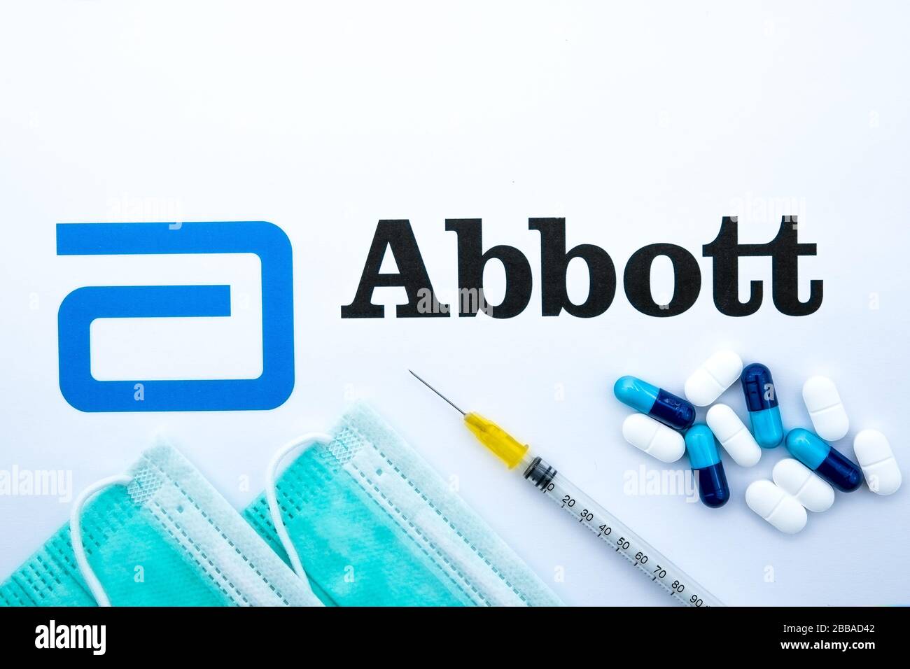 Stone / Regno Unito - 30 marzo 2020: Logo Abbott stampato come brochure e maschere virali sopra di esso con siringa e pillole. Concetto per coronavirus Foto Stock