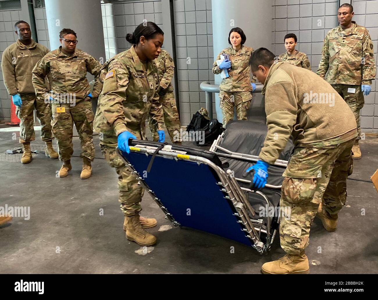 I soldati della Guardia Nazionale dell'Esercito di New York della 133rd Composite Supply Company, parte del comando di truppe 53rd, dimostrano l'assemblaggio di una culla al Centro Congressi Jacob K. Javits a New York City 26 marzo 2020. Il centro congressi sarà un sito di assistenza alternativo per alleviare la carenza di letti degli ospedali di New York come parte della risposta statale alla manifestazione COVID-19 (Stati Uniti Air National Guard foto di Senior Airman Sean Madden) Foto Stock
