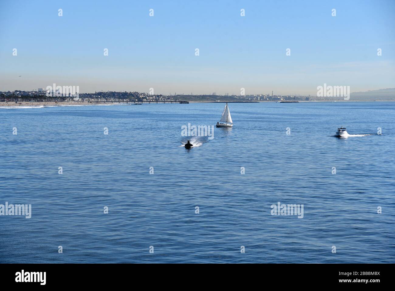 Barche a motore e barche a vela nella Baia di Santa Monica con il Molo di Venezia sullo sfondo Foto Stock