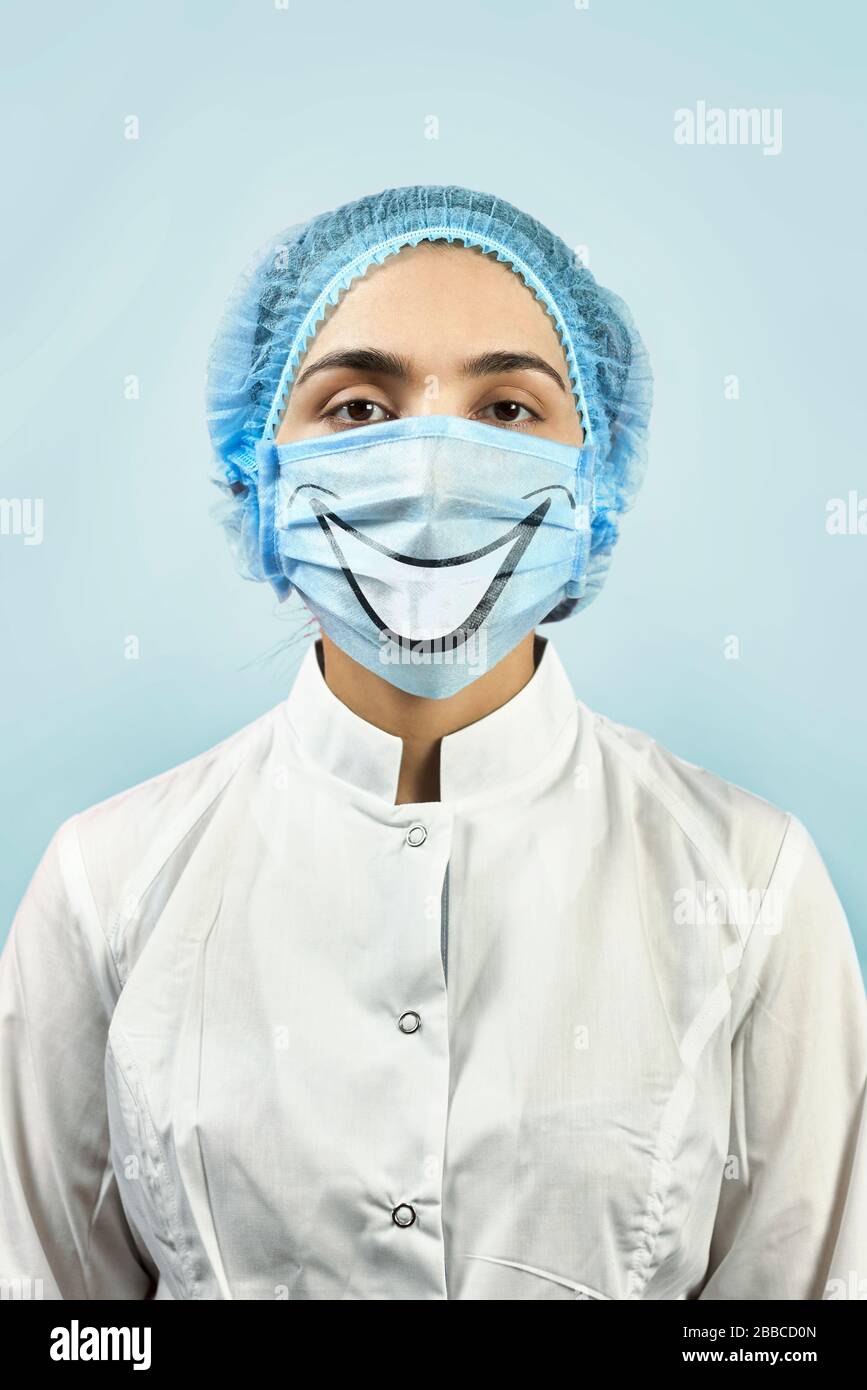 Terapista femminile con maschera medica sorridente divertente. Dentista in maschera  divertente Foto stock - Alamy