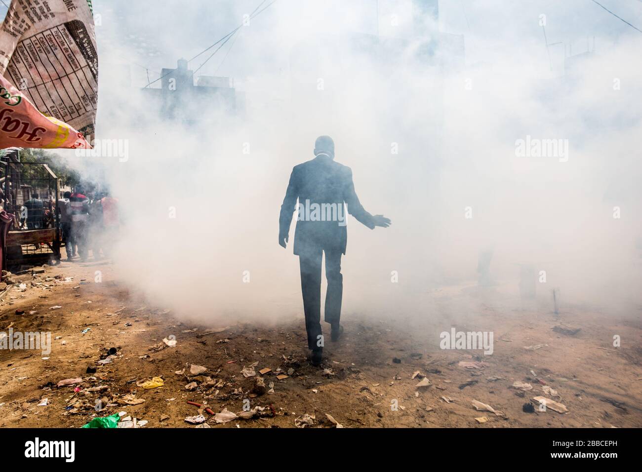 Dakar, Senegal. 30th Mar, 2020. Un uomo delle autorità locali attraversa il fumo disinfettante al mercato della Grand Dakar a Dakar, Senegal, 30 marzo 2020. Lunedì il Senegal ha segnalato 20 nuovi casi di COVID-19, portando il totale dei casi confermati a 162. Credito: Eddy Peters/Xinhua/Alamy Live News Foto Stock