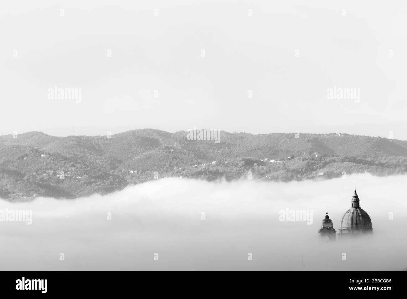 Vista surreale di Santa Maria degli Angeli chiesa papale (Assisi) quasi completamente nascosto dalla nebbia Foto Stock