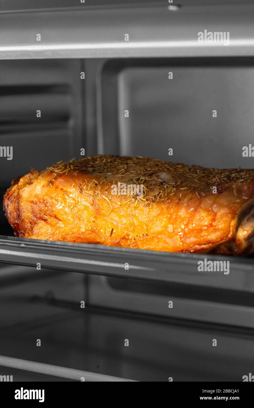Gamba di agnello su un vassoio di cottura arrostendo in un forno elettrico  grill. Con colore selettivo Foto stock - Alamy