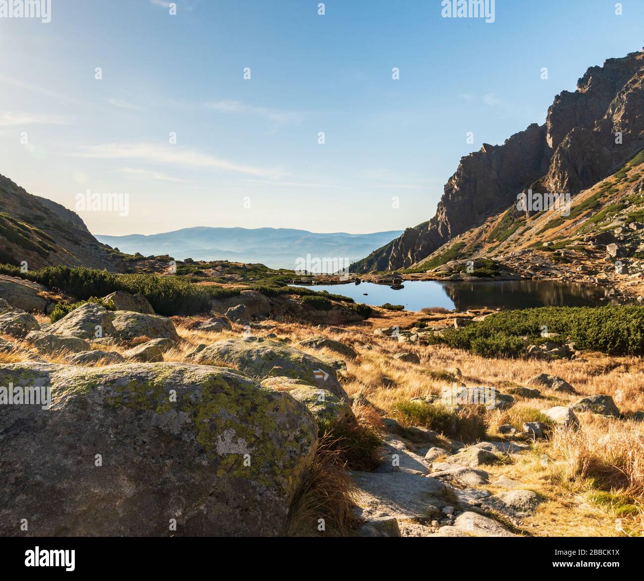 Lago Pleso nad Skokom con sentiero escursionistico e cime intorno a Vysoke Tatry montagne con Nizke Tatry catena montuosa sullo sfondo della Slovacchia Foto Stock