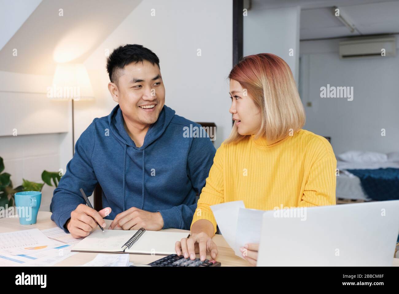 Asian coppia elenco home bilancio di bolletta finanziaria sul tavolo in cucina a nuovo house.family spese Foto Stock