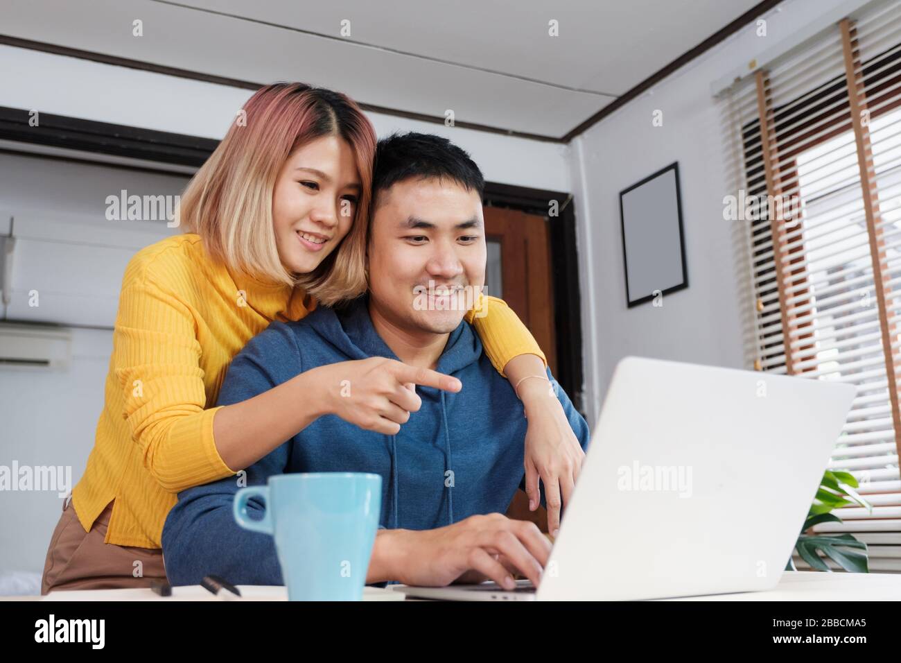 Asian coppia guardare video live straming on laptop at table at home.Lover passare il tempo insieme.Prenetevi una pausa dopo il lavoro Foto Stock