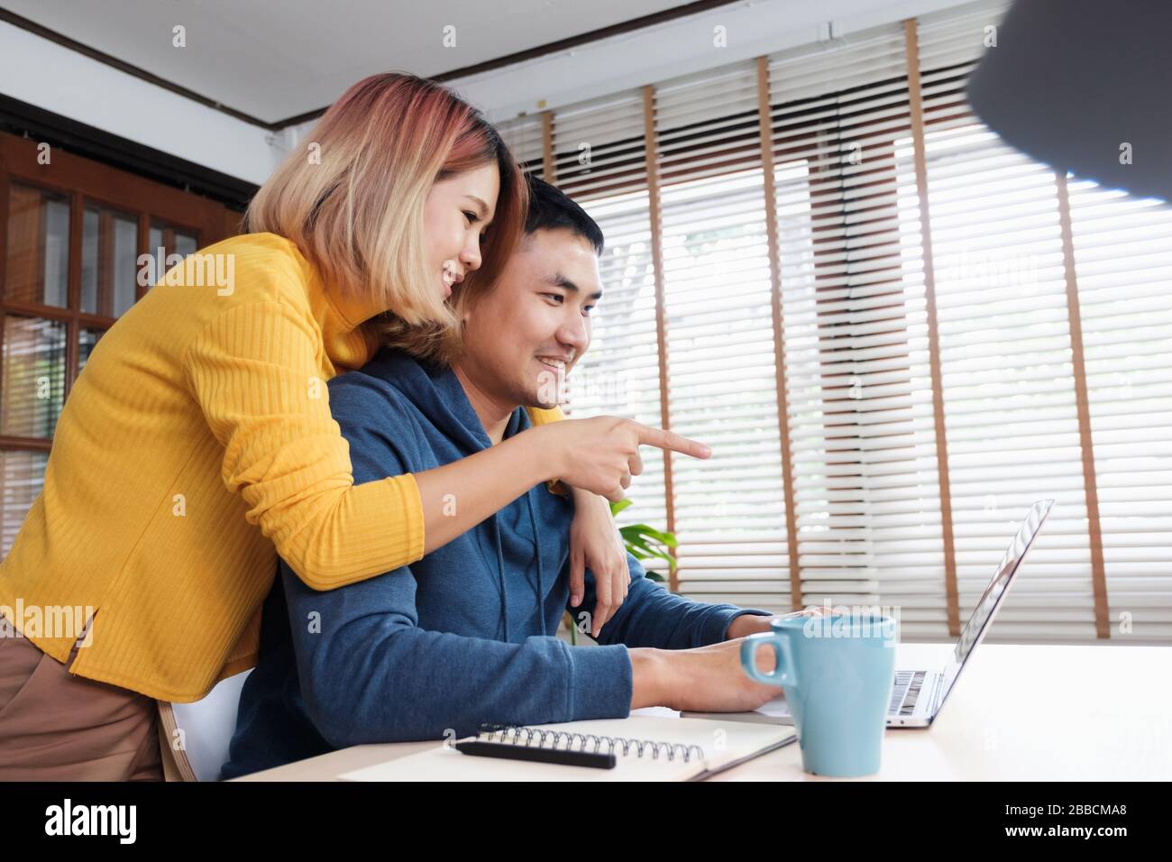 Asian coppia guardare video live straming on laptop at table at home.Lover passare il tempo insieme.Prenetevi una pausa dopo il lavoro Foto Stock