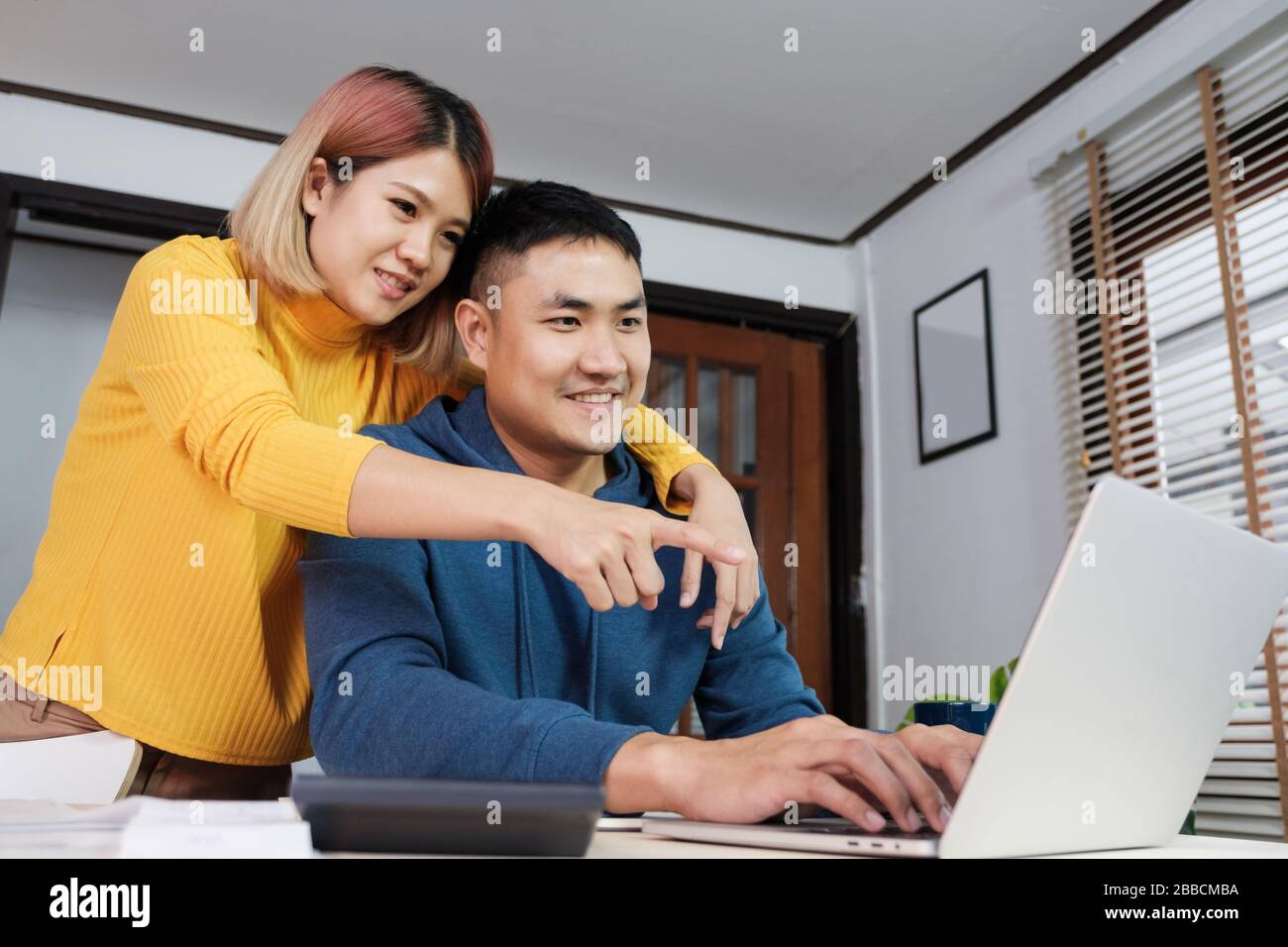 Asian coppia guardare video live straming on laptop at table at home.Lover passare il tempo insieme.Prenetevi una pausa dopo il lavoro Foto Stock