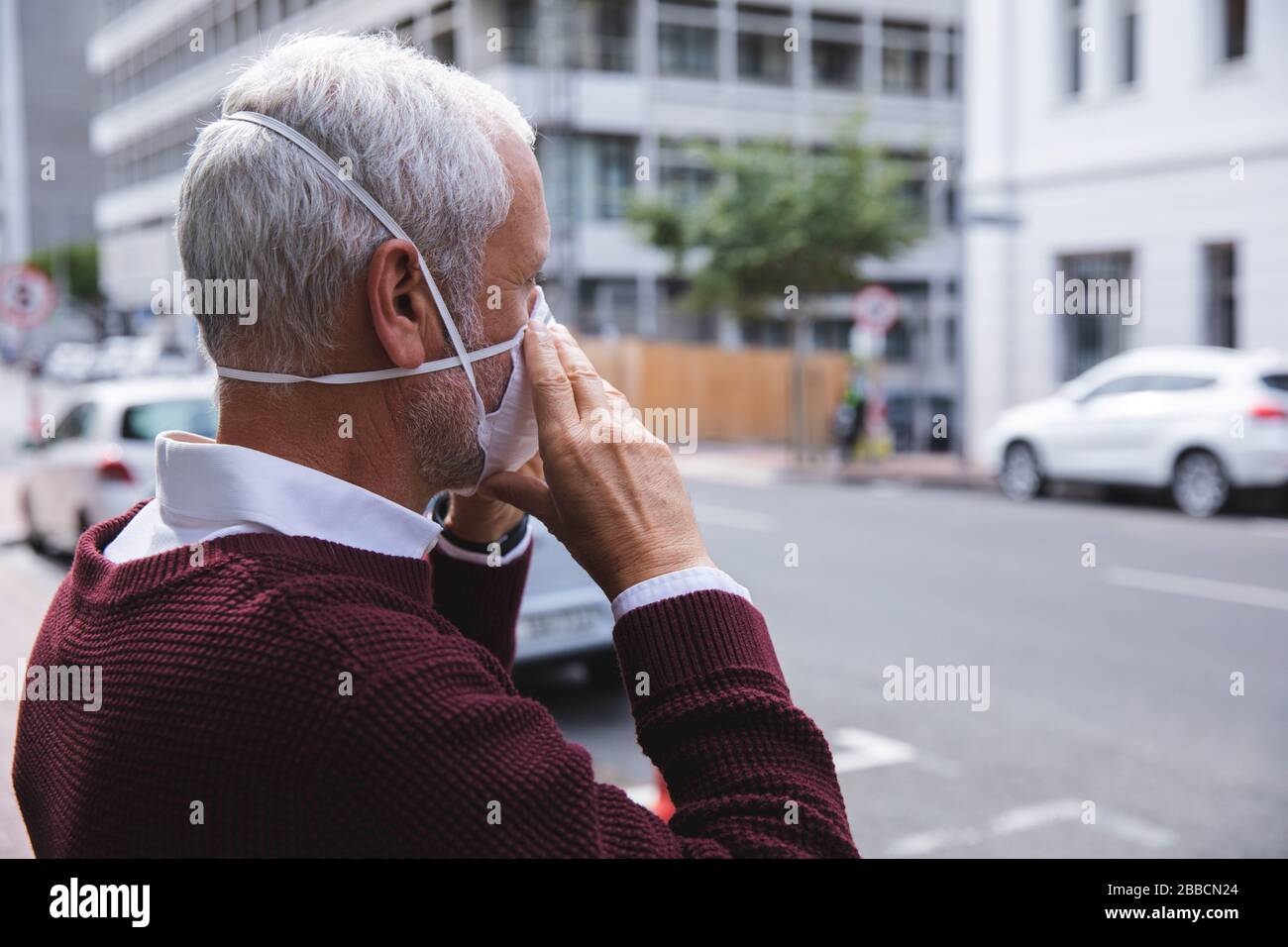 Uomo di mezza età che indossa la maschera di coronavirus Covid 19 in movimento Foto Stock