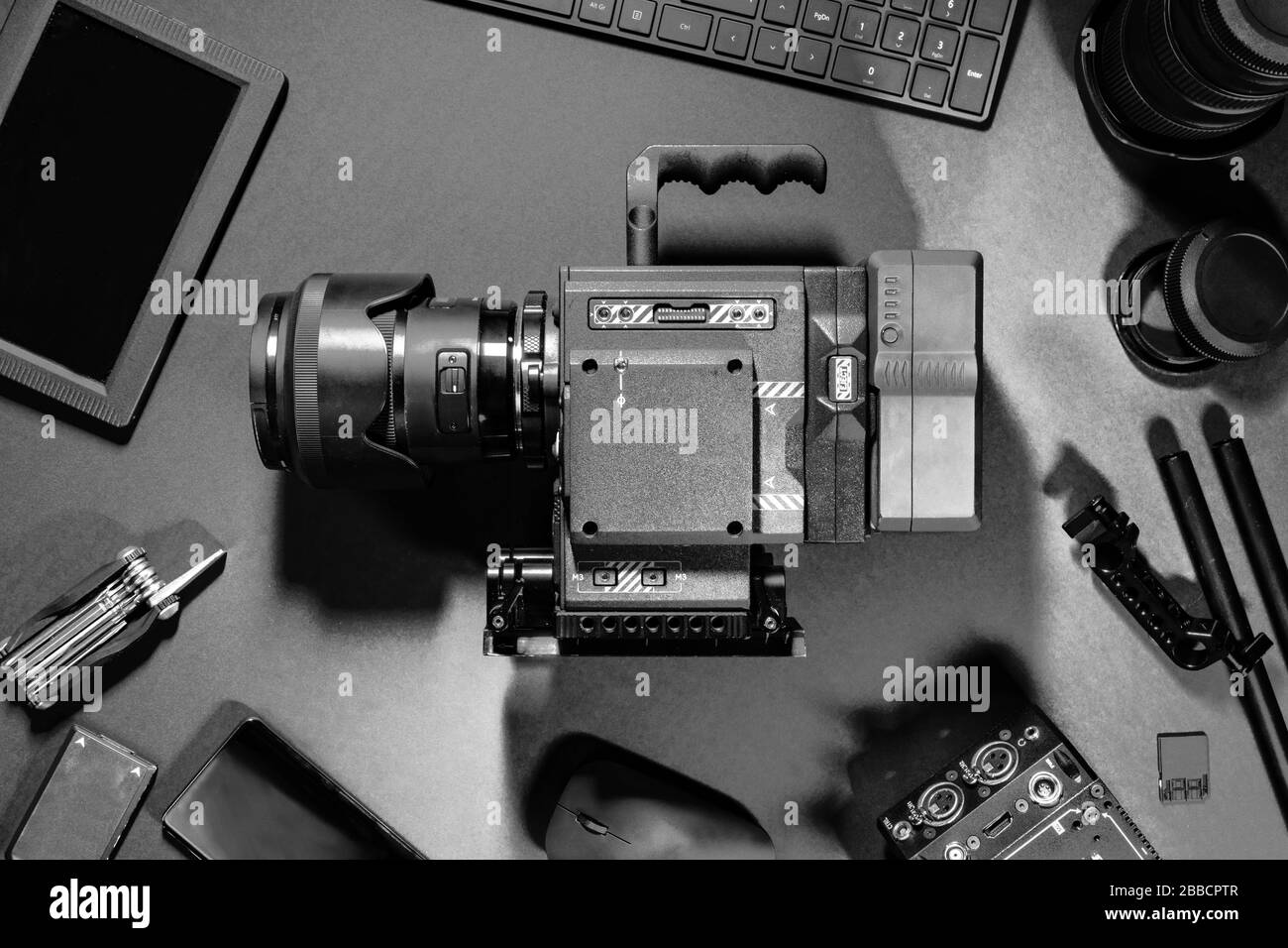 Vista dall'alto in bianco e nero di Creative Filmmakers Office Desk Camera and Supplies Foto Stock