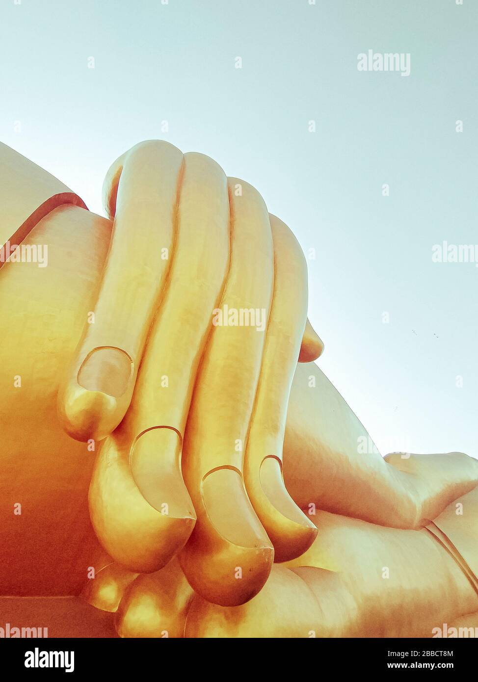 Avvicinati la mano della grande statua del buddha con il cielo blu a Wat Tha Muang Thailand, le statue più iconiche del Buddha d'oro Foto Stock