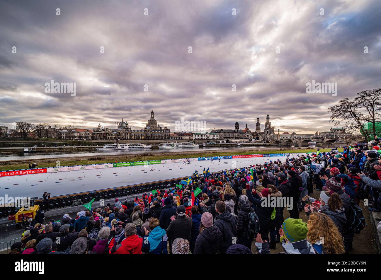 Persone che guardano la FIS sci di fondo sprint Coppa del mondo sulle rive del fiume Elba, lo skyline della città barocca in lontananza Foto Stock