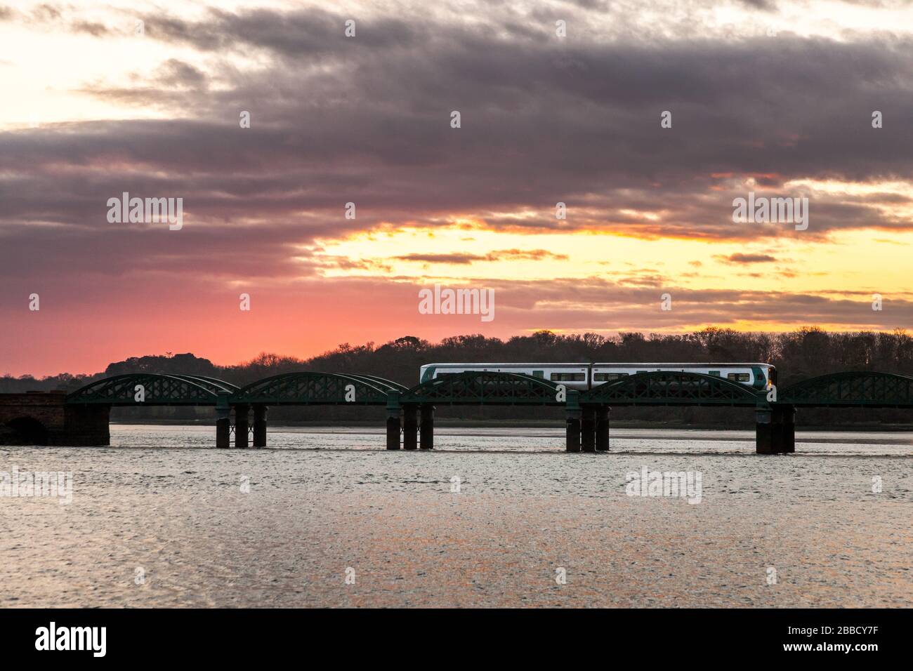 Isola di FOTA, Cork, Irlanda. 31st marzo 2020. Ora operando su un programma ridotto del 60% a causa delle restrizioni di viaggio di Covid-19, un treno di pendolari Irlandese di mattina presto attraversa il ponte per l'isola di FOTA sulla sua strada per Cobh, Co. Cork, Irlanda. – credito; David Creedon / Alamy Live News Foto Stock