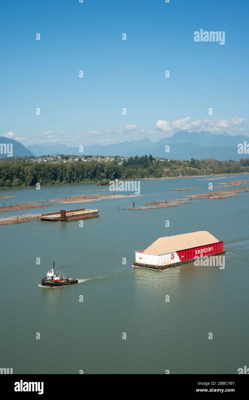 Chiatta di rimorchiatore e ciambella di legno nel fiume Fraser vicino a Surrey, British Columbia, Canada. Foto Stock