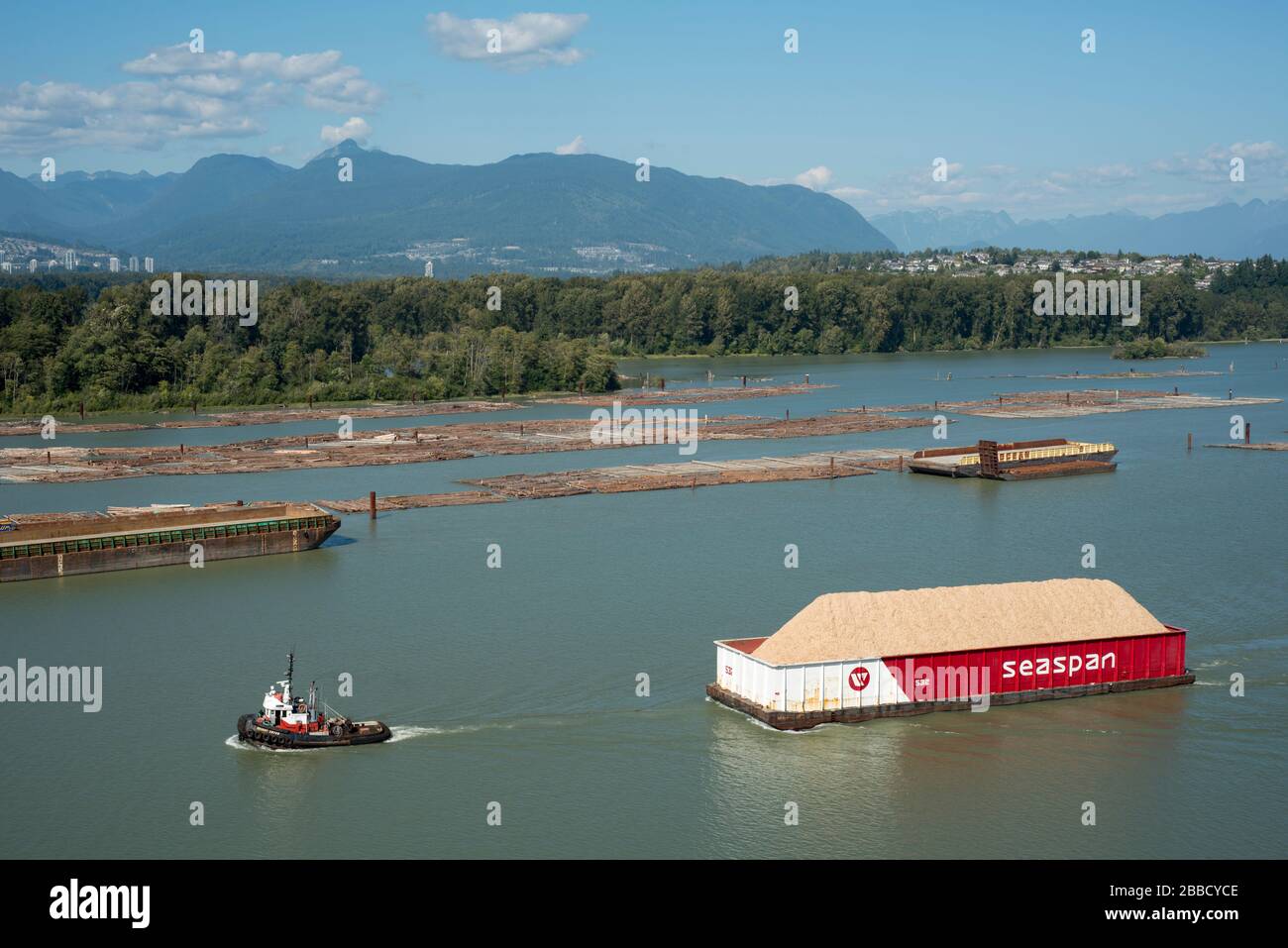 Chiatta di rimorchiatore e ciambella di legno nel fiume Fraser vicino a Surrey, British Columbia, Canada Foto Stock