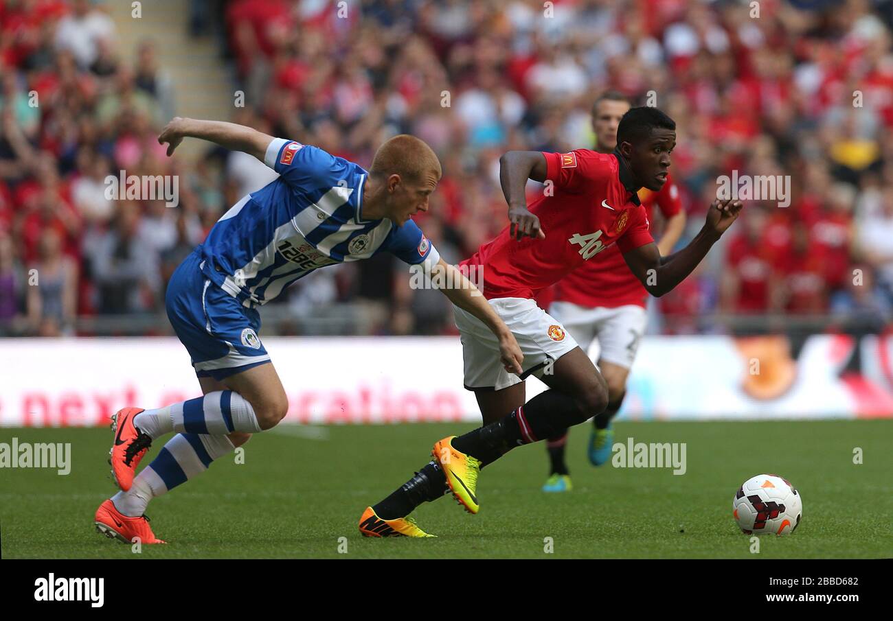 Ben Watson di Wigan Athletic (a sinistra) e Wilfried Zaha (a destra) del Manchester United si scontrano per la palla Foto Stock