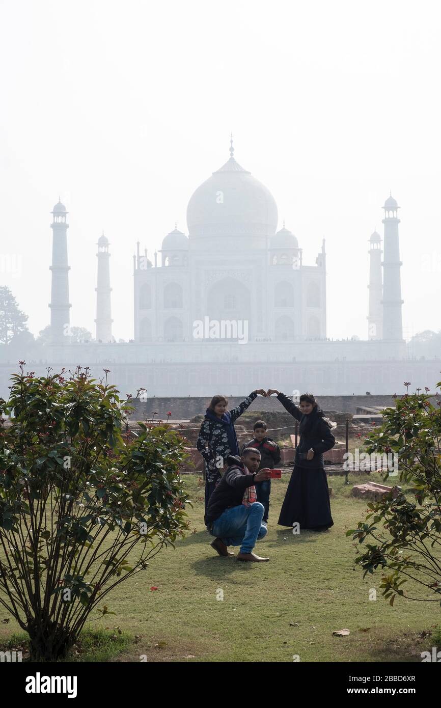 Una famiglia indiana in un giorno fuori posa per una foto di famiglia con Taj Mahal sullo sfondo Foto Stock