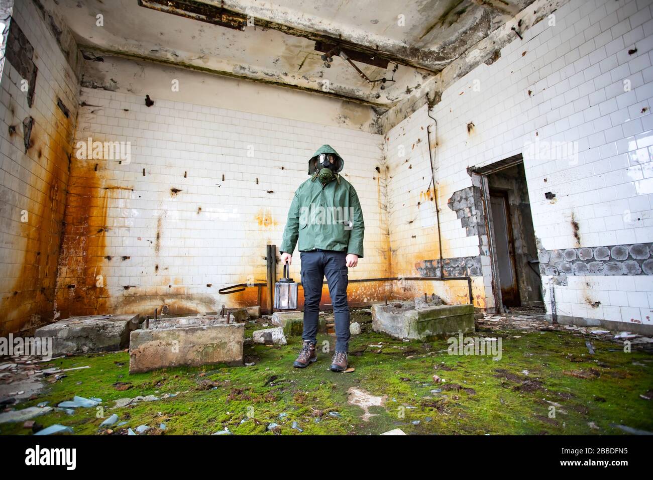 Post apocalittico sopravvissuto in maschera di gas in un edificio rovinato. Disastro ambientale, concetto di armageddon. Foto Stock