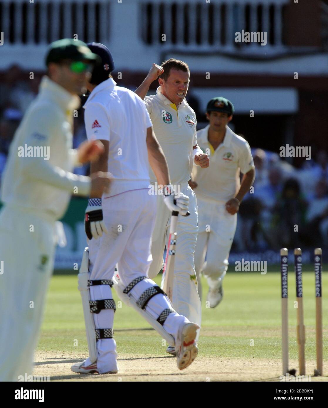 Alastair Cook dell'Inghilterra lascia il campo dopo essere stato piegato dall'australiano Peter Riddle (centro) Foto Stock