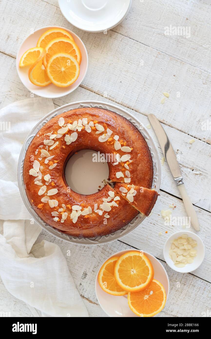 Torta d'arancia servita su un tavolo di legno bianco. Stile piatto Foto Stock