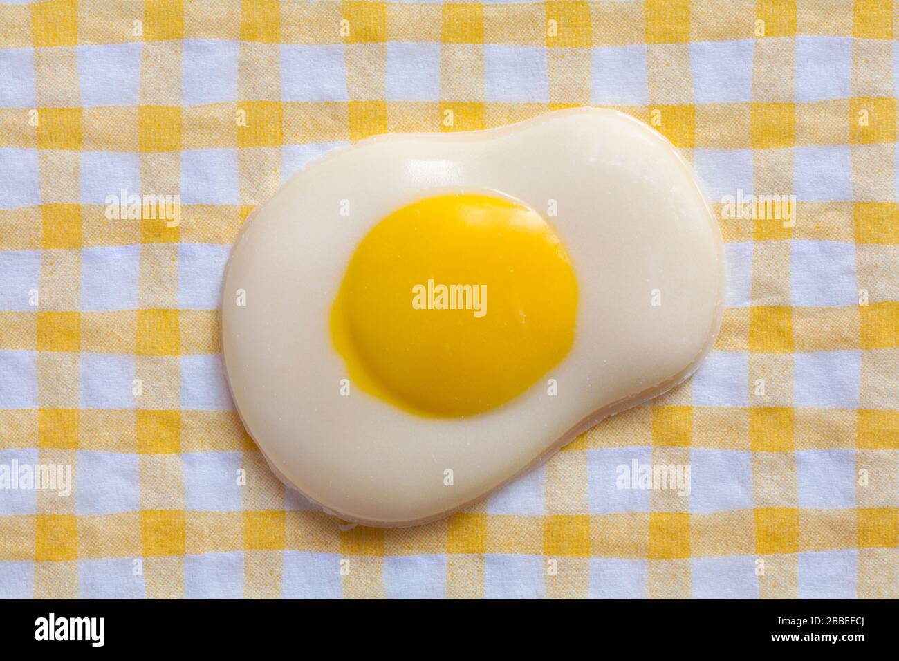M&S Fried Egg decorato solido cioccolato bianco pronto per Pasqua set su tovagliolo bianco e giallo controllato serviette Foto Stock