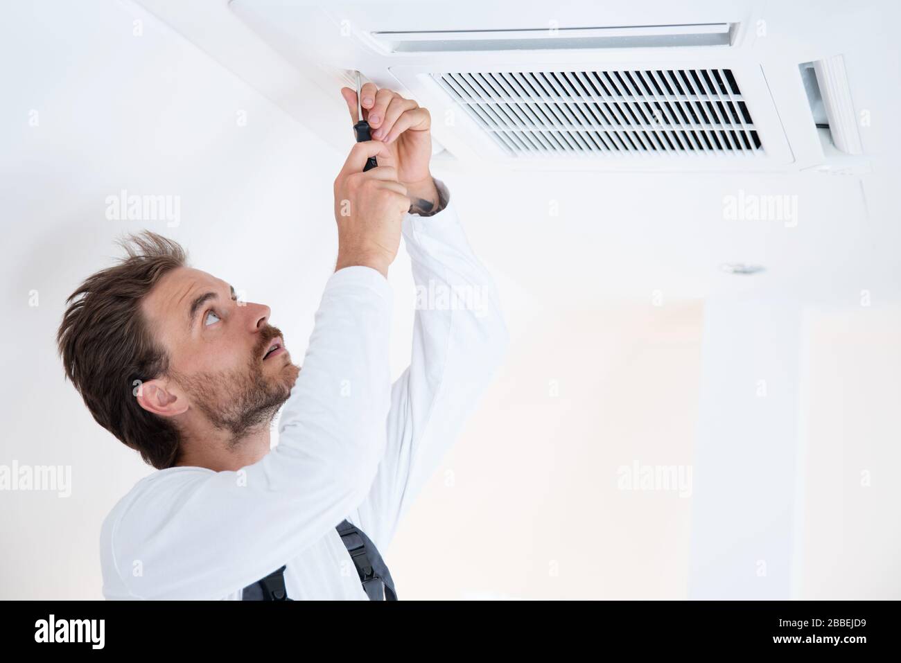 Il tecnico dell'aria condizionata lavora su un condizionatore d'aria Foto Stock