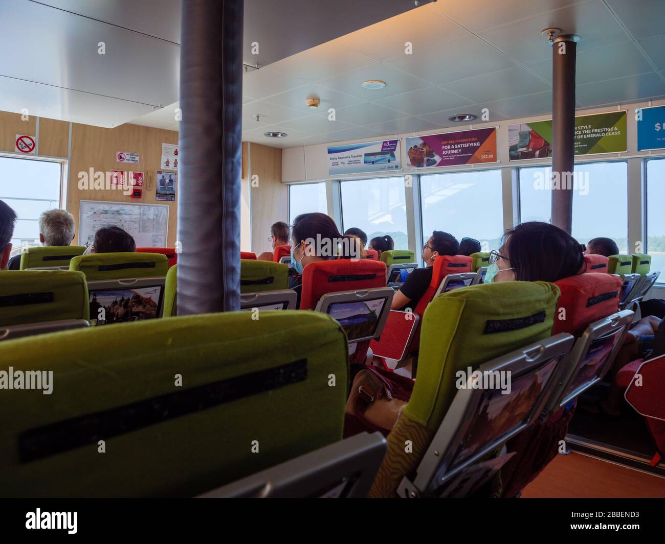 BINTAN, INDONESIA – 9 MAR 2020 – passeggeri del turismo che indossano maschere durante un viaggio in traghetto dall'isola di Bintan a Singapore. Bintan è un popolare tour Foto Stock