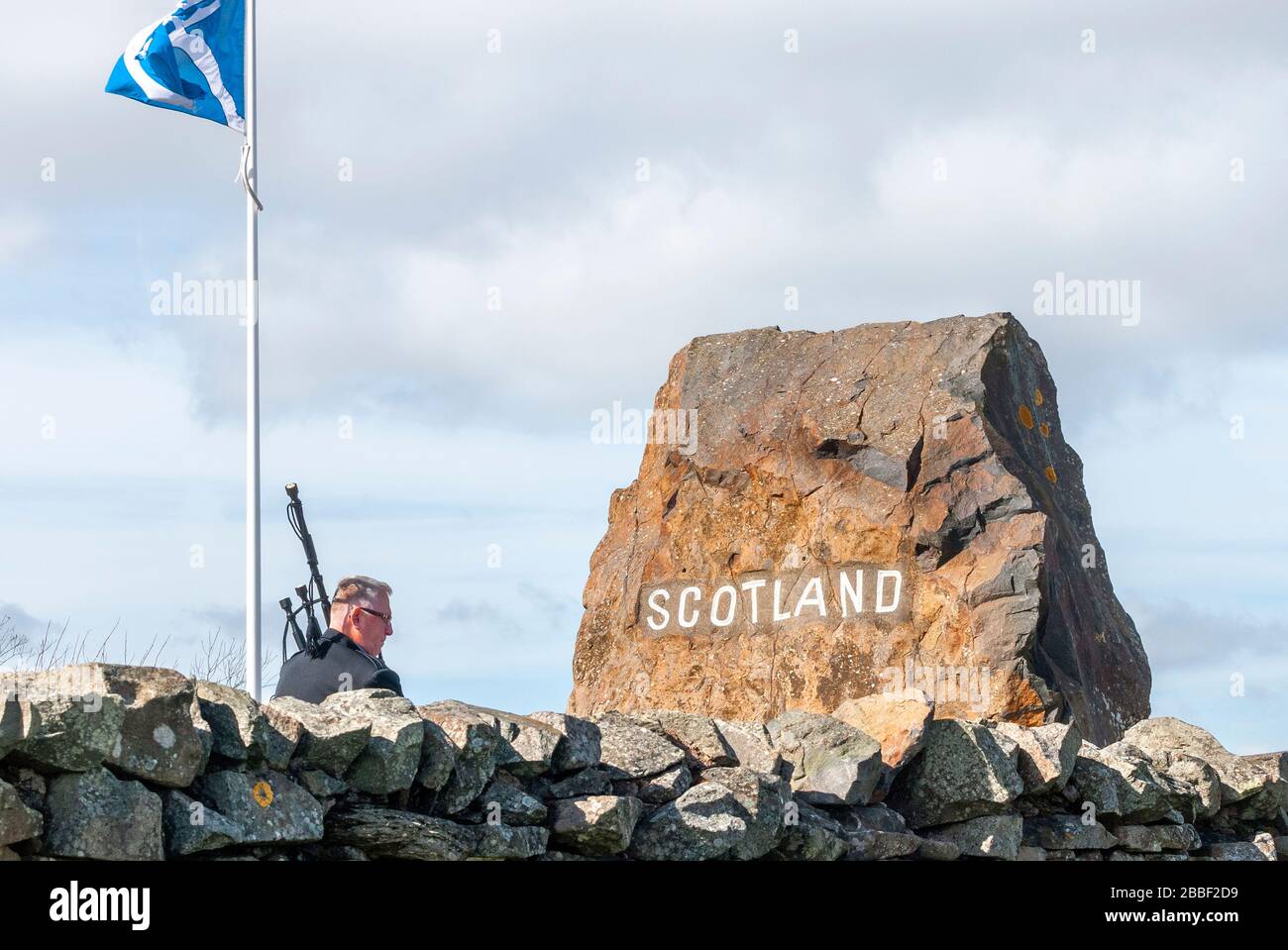 Un accogliente piper al carter Bar - Piper, Alan Smith, che vi dà il benvenuto in Scozia dal lato inglese del confine scozzese inglese al carter's Bar Foto Stock