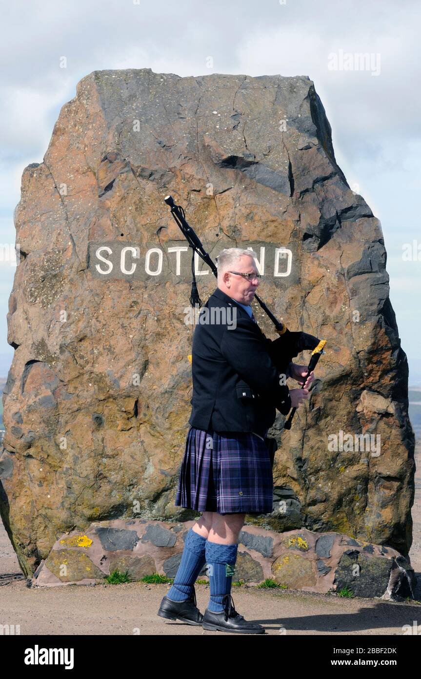 Un accogliente piper al carter Bar - Piper, Alan Smith, vi dà il benvenuto in Scozia dall'Inghilterra. Foto Stock