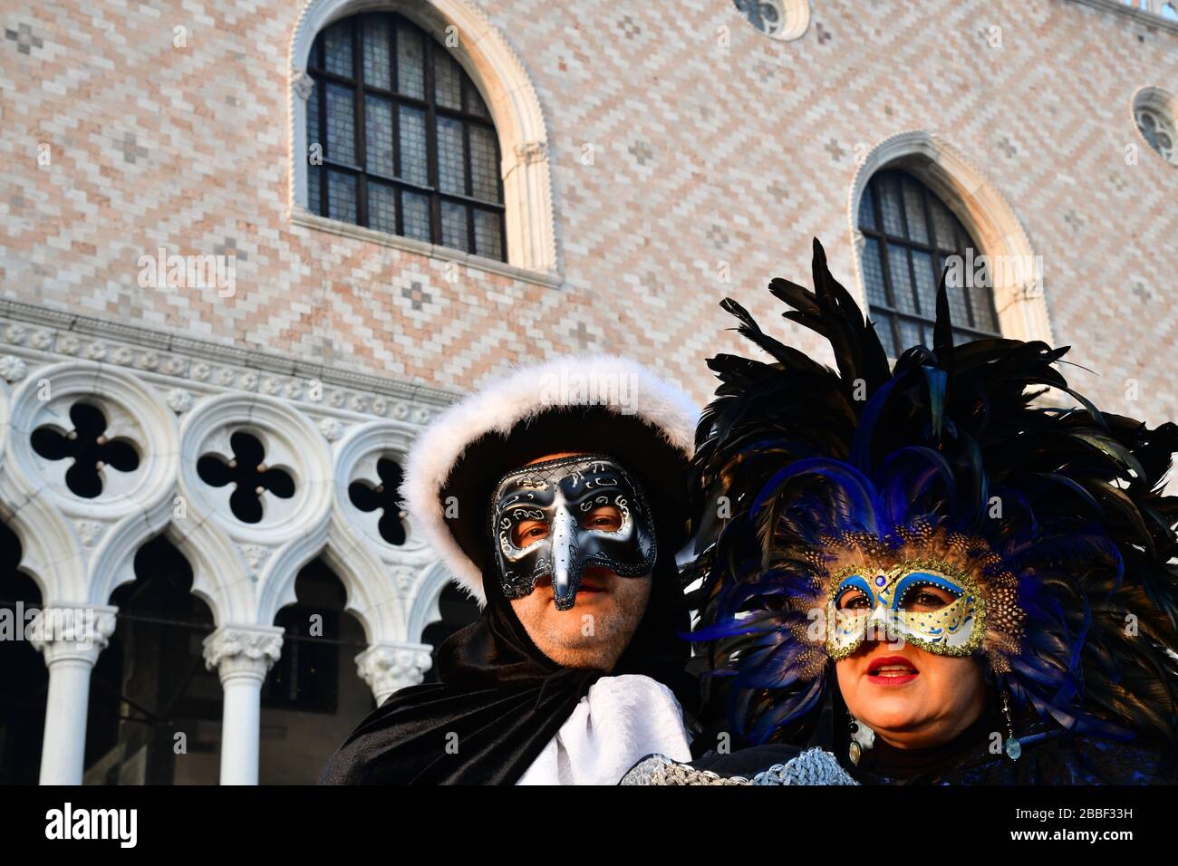 vista a basso angolo di un uomo e di una donna con maschera per la tradizionale palla masquerade per il prossimo carnevale Foto Stock
