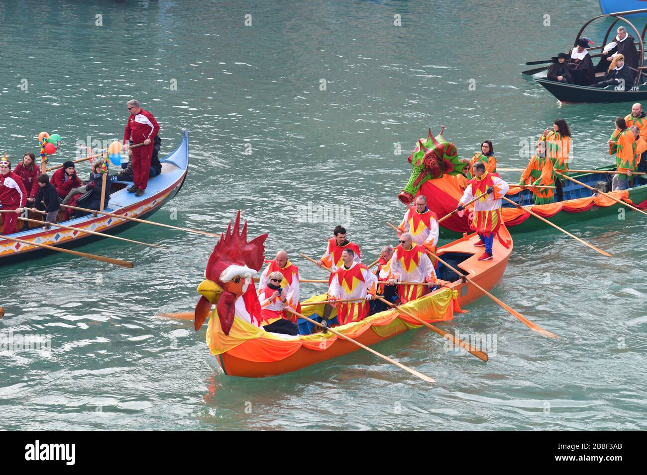 Venezia, Italia-Febbraio 2020; vista ad alto angolo della Festa Veneziane sull'acqua con strutture galleggianti e persone in barca in costumi in parte di t. Foto Stock